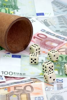 Dice shaker and dices on euro notes