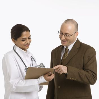 Indian mid adult woman doctor talking with man in business suit.