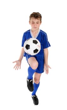 A boy using a soccer ball skills practice.  Ball has some motion.  White background.