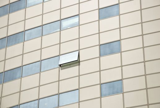 Detail of the facade office building. Aluminum panel and stained glass. One window is open. Outdoor. Close up.