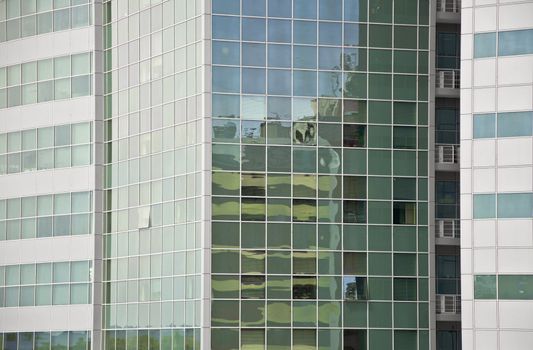 Detail of the facade office building. Aluminum panel and stained glass. One window is open. Outdoor. Close up.