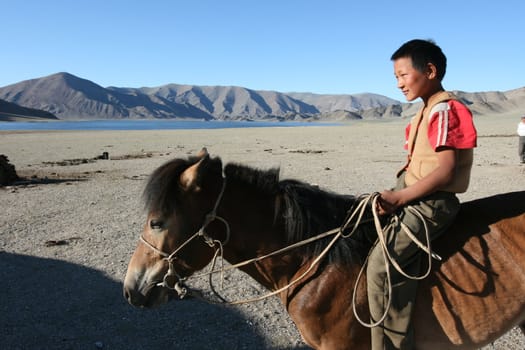 Mongolian boy racing on a horse 