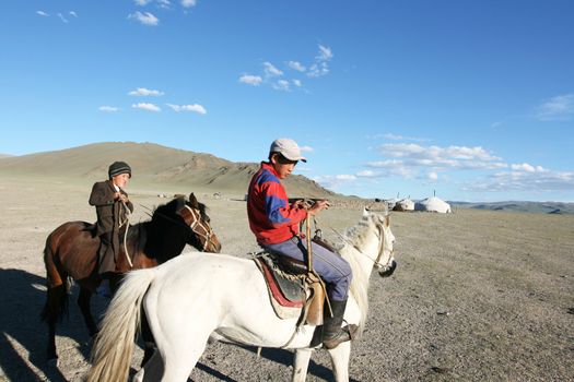 Mongolian boy racing on a horse in front of nomads tent- August 06, 2008. Mongolia