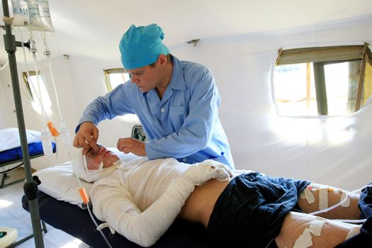 VINNYTSYA, UKRAINE - JUNE 10, 2008: surgeons in operative room in military mobile hospital during a medical military trainings  on June 10, 2008 in Vinnytsya, Ukraine