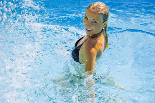 beautiful woman in pool under water drops