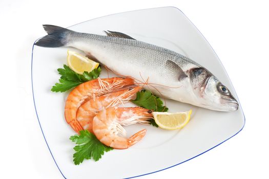 plate with sea bass, prawns, lemon and parsley isolated on white background with clipping path