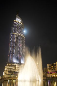 Night image of a modern building and a fountain, Dubai, United Arab Emirates.
