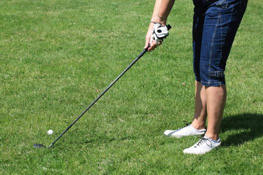 A woman in golf position, holding a golfclub