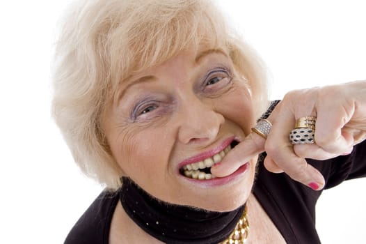 close up of old woman keeping finger in her mouth on an isolated background