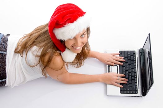 laying young female with christmas hat and laptop on an isolated white background