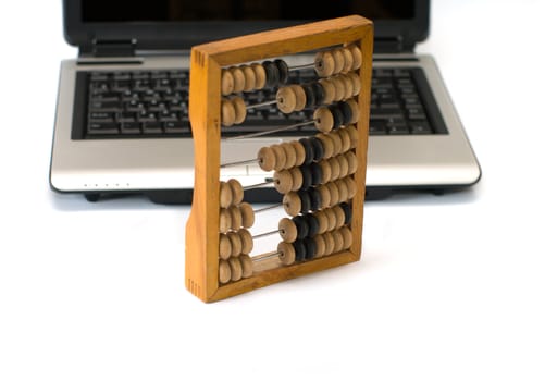 Old wooden abacus and the laptop, it is isolated on a white background.