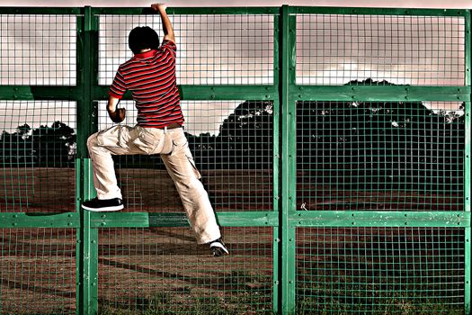 man climbing on barbed wire fence