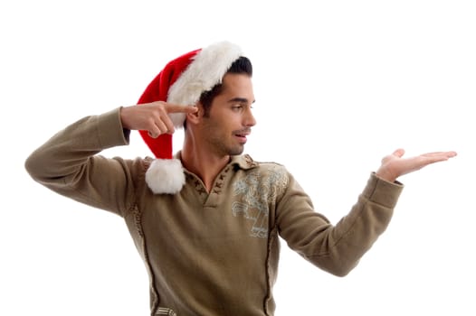 young man wearing christmas hat and indicating to his hand with white background