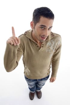 young guy pointing upwards and looking at camera on an isolated white background