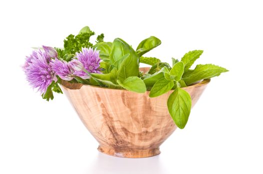 Fresh picked herbs in a handmade wooden bowl.