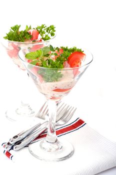 Salad containing ripe sliced tomato and fresh herbs.