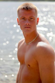 Sexy Young Man Standing In The Sun Near Water