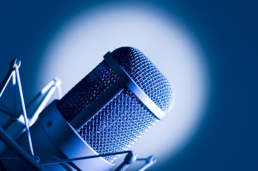 Microphone in studio. Dark blue light.