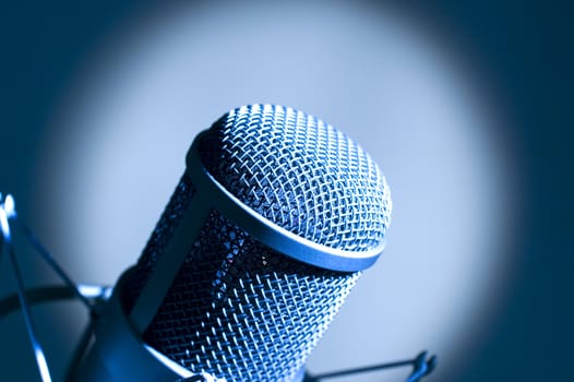 Microphone in studio. Dark blue light.