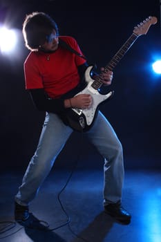 Musician playing electric guitar on stage