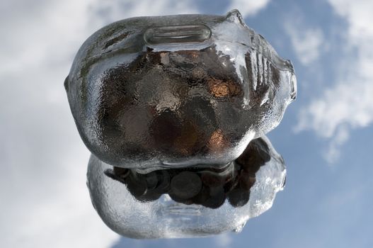 glass piggy bank floating in the sky with a reflection in the clouds