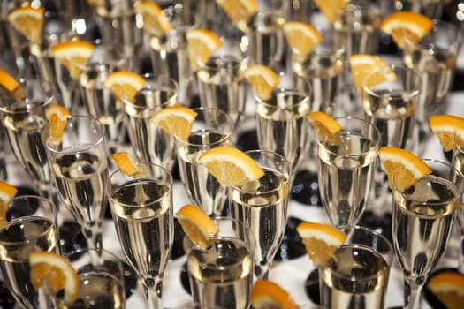 Several Glasses of white wine decorated with oranges