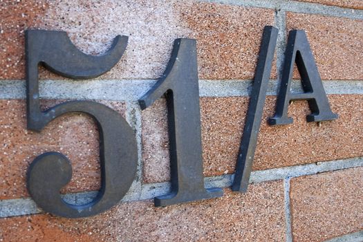 civic number of iron on brick of an private house