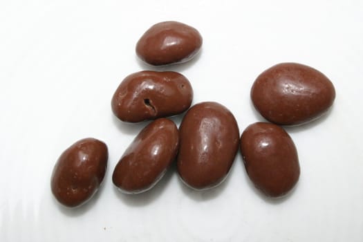 seven isolated chocolate raisins on white background