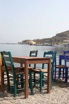 traditional tables and chairs at greek taverna by the sea