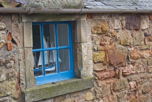 miniature sailing boat standing in a window of a colltage