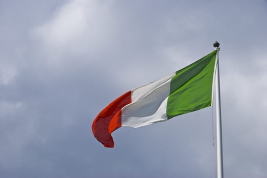 italian flag blowing in the wind on a cloudy day