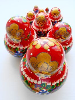 Russian nest-dolls on the white background, painting, wooden