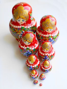 Russian nest-dolls on the white background, painting, wooden