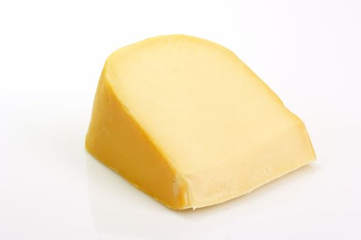 A big chunk of gouda cheese on bright background
