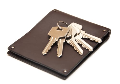 leather purse with keys from the house on white background