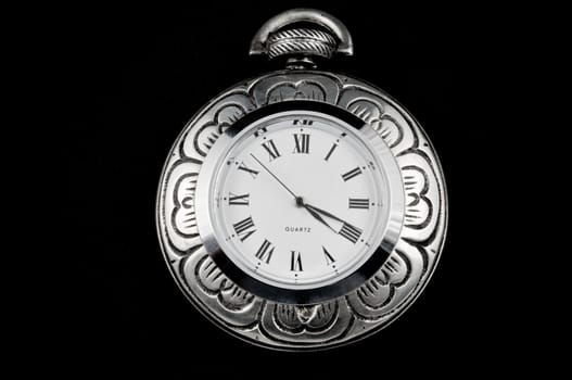 Elegant flower carved steel pocket watch isolated on black