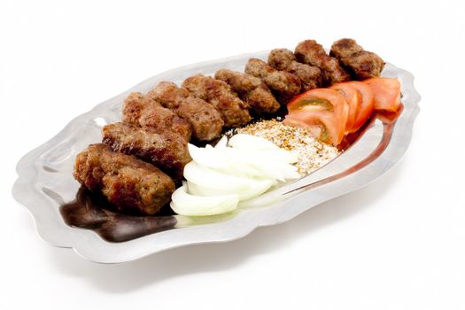 Kebabs with tomatoes and onion on silver dish