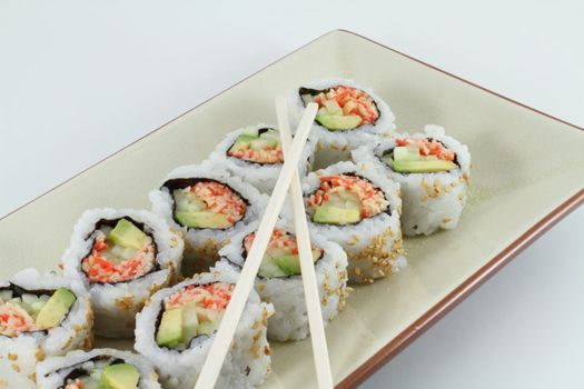 Fresh sushi with chop sticks in a traditional table setting.