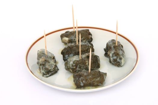 cooked wraped and stuffed grape leafs with rice and meat traditional greek food dolmadakia with tooth sticks on dish