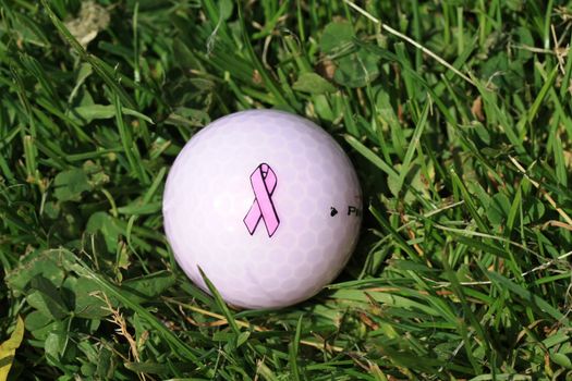 Golfball with pink ribbon  breast cancer awareness logo