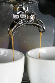 Detail image of two cups of espresso being made in an industrial profesional machine