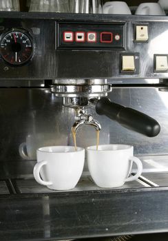 Detail image of two cups of espresso being made in an industrial profesional machine