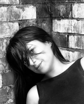 pretty young woman leaning against a wall
