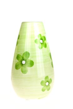 a green vase with flowers on white