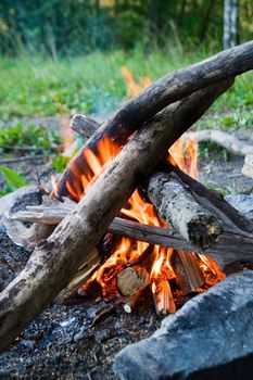 Camp fire in the outdoors, open flame.