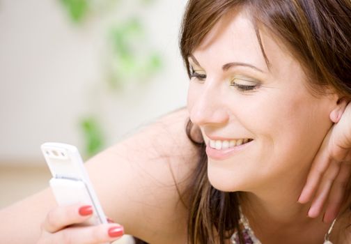 portrait of happy woman with white phone (focus on smile)