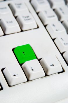 Arrow keys on a desktop computer keyboard with the up arrow green