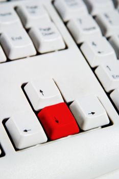 Arrow keys on a desktop computer keyboard with the down arrow red