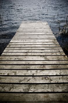 Weathered wooden pier - intentional vignetting and desaturation.