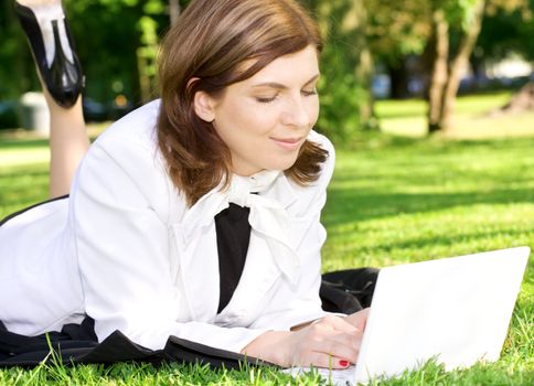 picture of office lady with laptop computer laying on the grass